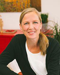 Porträt einer freundlichen und professionellen Beraterin in heller, einladender Umgebung. frau, porträt, lächeln, beraterin, professionell, blond, schwarze-jacke, weißes-shirt,